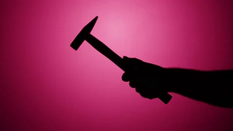 Man holding hammer close-up, shadow silhouette of hand with mallet on pink neon Stock Footage 170735629