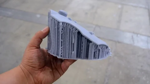 Man holding in hand an object created on a 3D printer from hardened rubber Stock Footage 277918281