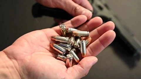 A man holding a handful amount of self defense rounds for concealed carry gun Stock Footage 146288695