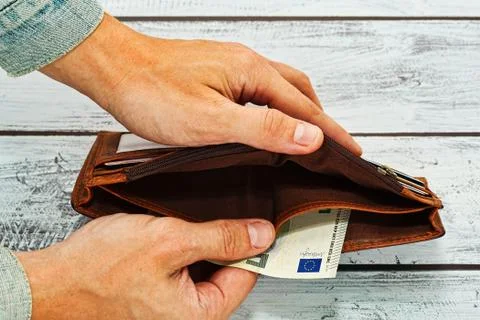 Man holding in hands almost empty wallet Stock Photos
