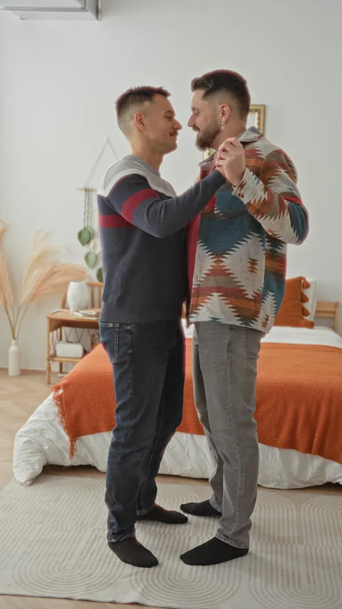 Man holding hands and slow dancing beside a bed in a cozy bedroom inside a .. Stock Footage 339217204