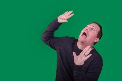 Man holding hands up looking up being attacked from above Stock Photos