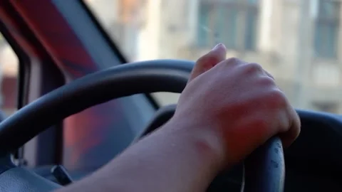 Man holding hands on steering wheel. Driving car in the sunset light. Stock Footage 150572972