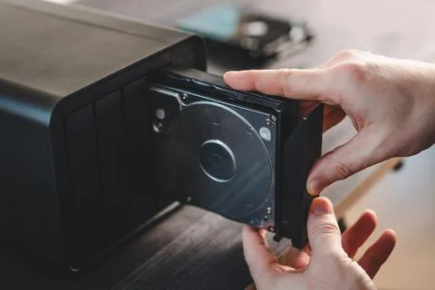 Man Holding A Hard Disk Drive From Bay Of Home Nas Server Storage System Stockfoto's