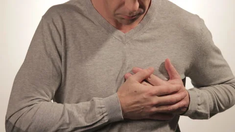 Man holding his chest with both hands, having heart attack or painful cramps 動画素材 99573223
