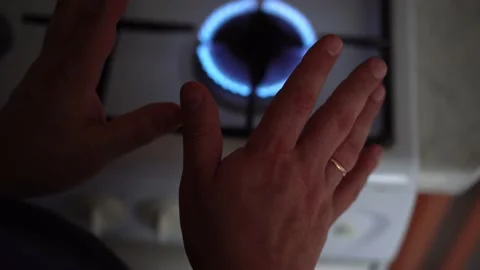 Man holding his hands over burning fire. Room heating, natural gas burn on stove Stock Footage 220000313