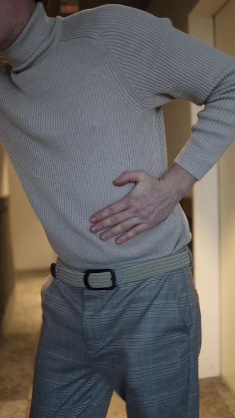 A man holding his side with one hand, appearing to experience discomfort or pain Stock Footage 292515182