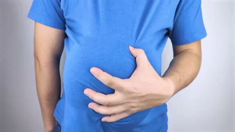 The man is holding onto his swollen belly. Bloating, flatulence, gas, malfunctio Stock Footage 141017800