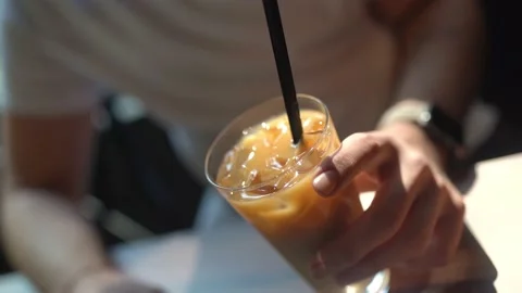 Man holding iced latte at computer Stock Footage 180369574