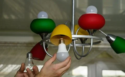 Man holding incandescent bulb and LED bulb before changing lamp.Lamp symbol.. Stock Photos