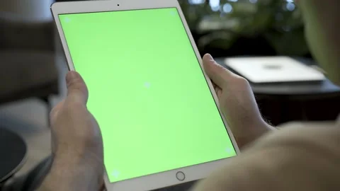 Man holding iPad tablet device in portrait position. Man is looking at the Stock Footage 171533243
