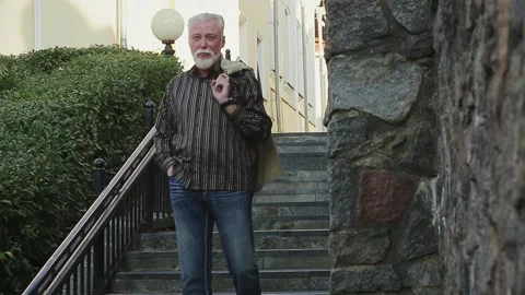 Man holding jacket on shoulder by staircase Stock Footage 168911115