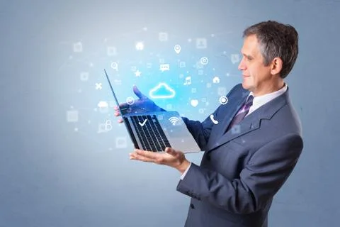 Man holding laptop with cloud based system notifications Foto stock