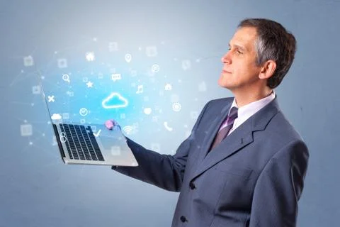 Man holding laptop with cloud based system notifications Foto stock