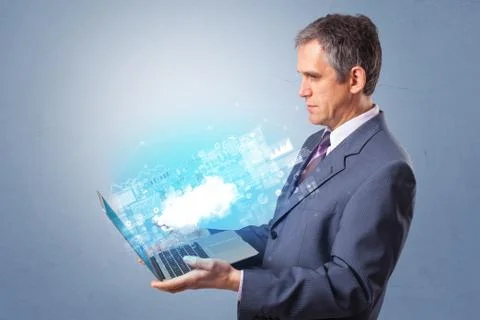 Man holding laptop with cloud based system notifications Foto stock