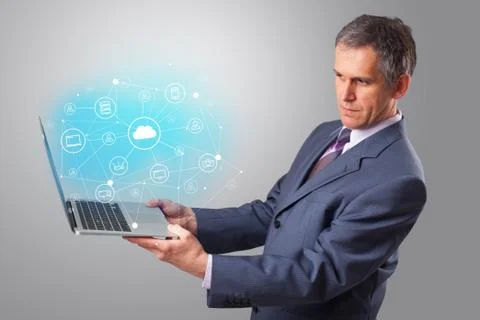 Man holding laptop with cloud based system concept Stock Photos