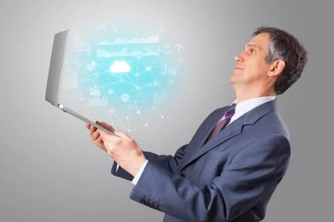 Man holding laptop with cloud based system concept Stock Photos