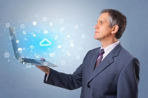 Man holding laptop with cloud based system notifications Foto stock