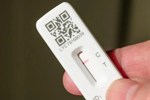 Man holding lateral flow test negative result, Covid testing UK Foto stock