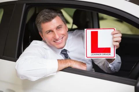 Man holding a learner driver sign sitting behind the wheel Stock Photos