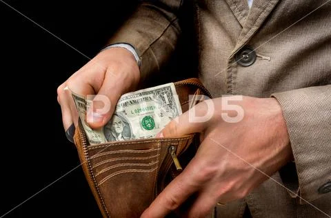 Man holding leather wallet with only one dollar inside isolated on black Stock Photos