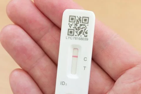 Man holding LFT Test negative result in hand, Covid testing, UK. Foto stock