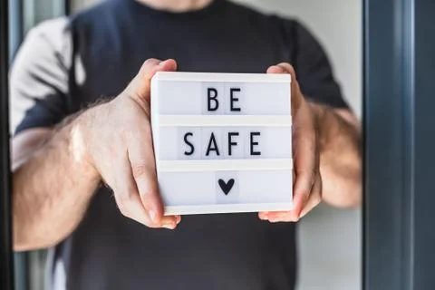 Man holding lightbox with text Be safe in his hand Foto stock