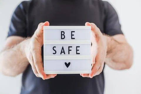 Man holding lightbox with text Be safe in his hand Stock-Fotos
