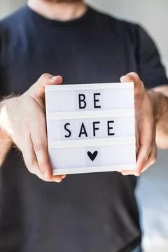 Man holding lightbox with text Be safe in his hand Healthcare and Safety c... Stock Photos