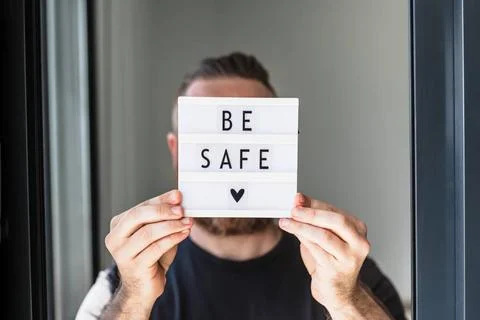 Man holding lightbox with text Be safe in his hand Healthcare and Safety c... Stock Photos