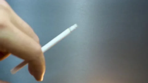 The man holding lit cigarette between fingers Stock Footage 232715253