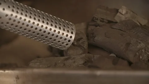 Man holding a looft lighter against the coal pieces Video stock 85965108