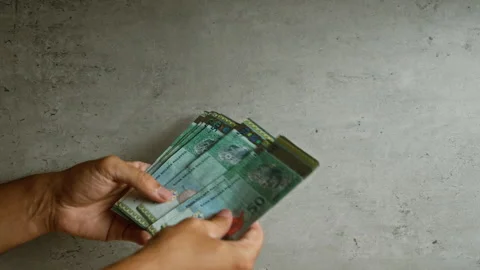 Man holding malaysian ringgit against a concrete background, highlighting d.. Stock Footage 288442686