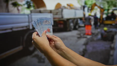 Man holding malaysian ringgit banknotes in hand on an urban construction si.. Stock Footage 301125220