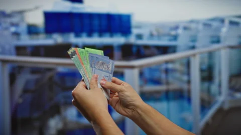 Man holding malaysian ringgit banknotes on a boat with a port backdrop duri.. Stock Footage 303423995