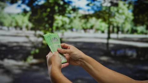 Man holding malaysian ringgit banknotes in an outdoor urban park with blurr.. Stock-Footage 306404155