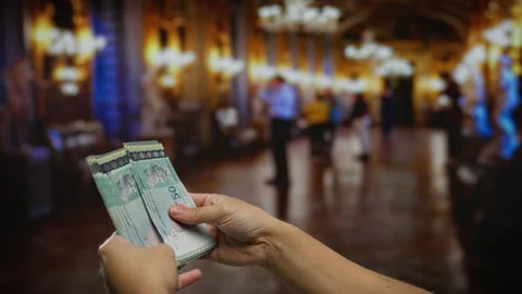 Man holding malaysian ringgit indoors with blurred people and chandeliers i.. Stock-Footage 302499838