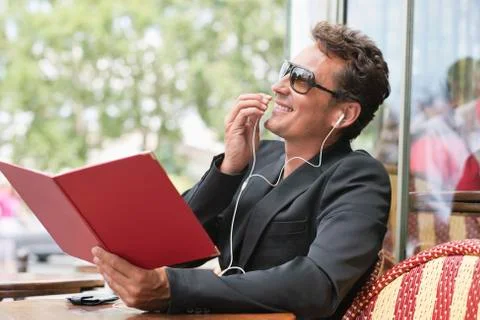 Man holding a menu and talking on a mobile phone in a restaurant, Paris, Stock Photos