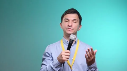 Man holding a microphone and gesturing with his hand, actively communicating Stock Footage 342773490