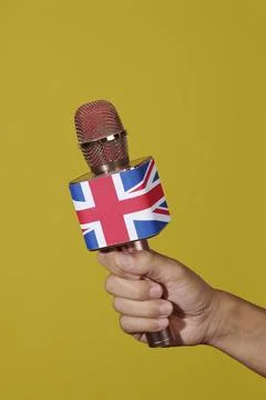 Man holding a microphone patterned with the union jack Stock Photos