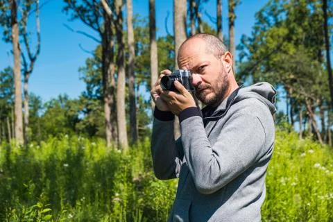 Man holding mirror less camera, shooting in forest Stock Photos