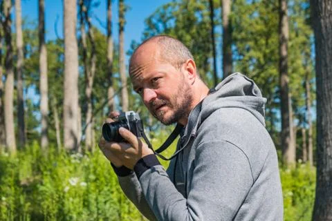 Man holding mirror less camera, shooting in forest Stock Photos