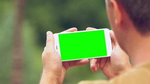 Man holding a mobile horizontally as he reads Video stock 112155695