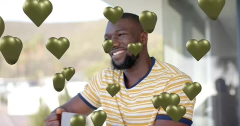 Man holding mug touching beard on patio, green hearts appearing and sparking Stock Footage 321734447