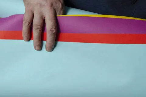 Man is holding multi-colored sheets of paper in his hand. Stock Photos