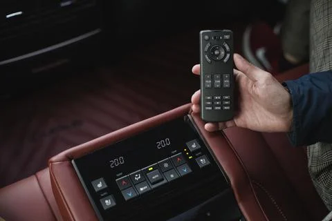 A man holding a multimedia remote control in a car Stock Photos