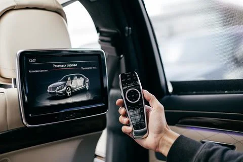 A man holding a multimedia remote control in a car Stock Photos