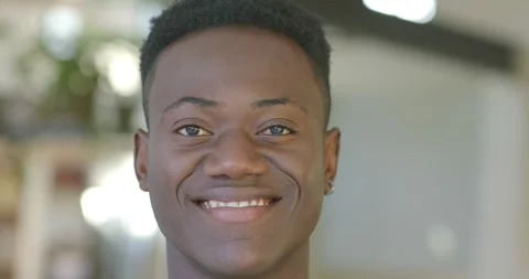 Man holding neutral face, smiling and laughing on set reacting to off-camera Stockbeeldmateriaal 340613050