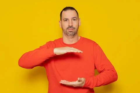 A man holding an object between his hands, showing, offering or advertising.. Stock Photos