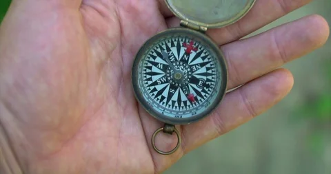 Man holding an old compass in hand and rotate around the axis. Stock Footage 127747329